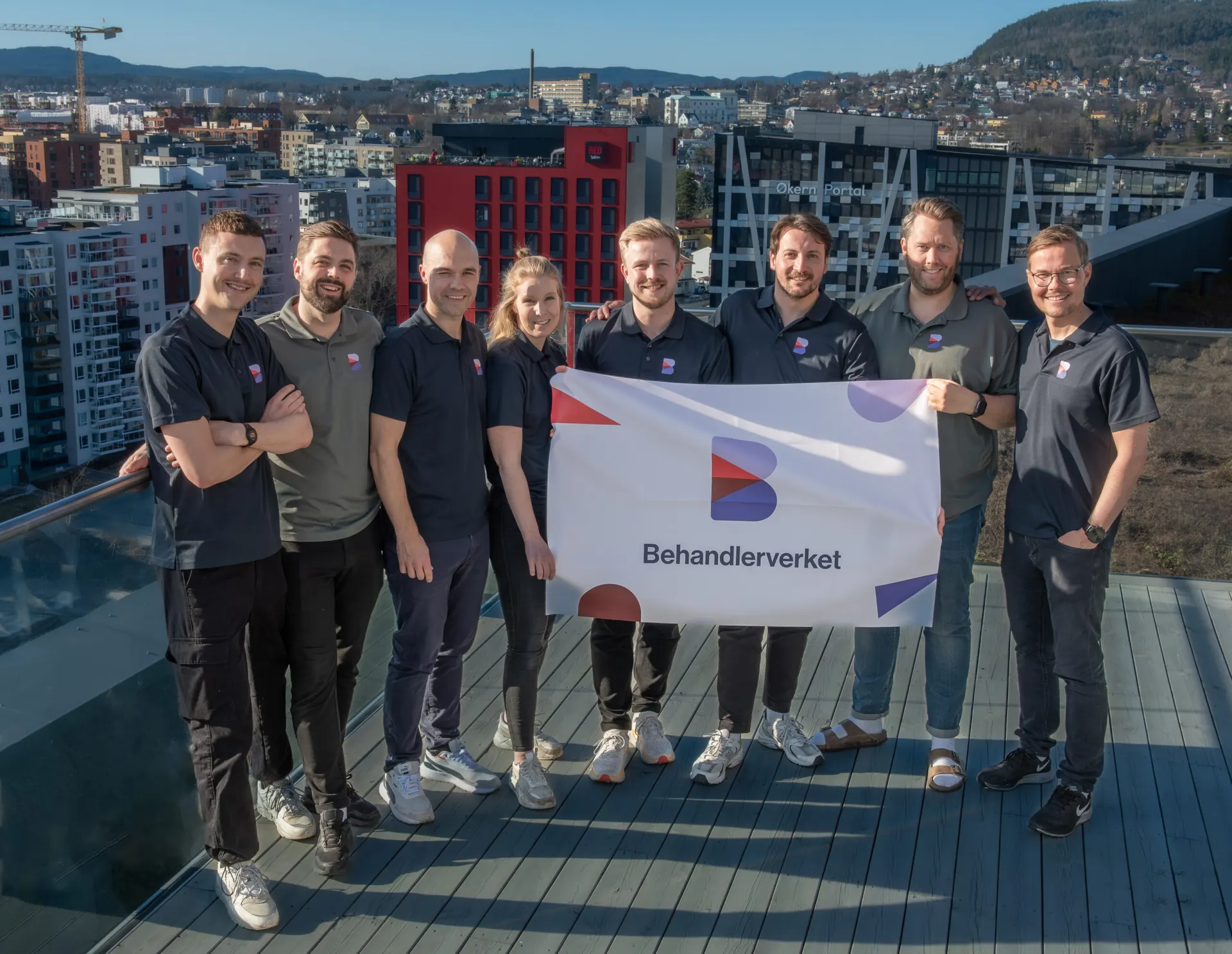 Behandlerverket-teamet samlet med et Behandlerverket-banner